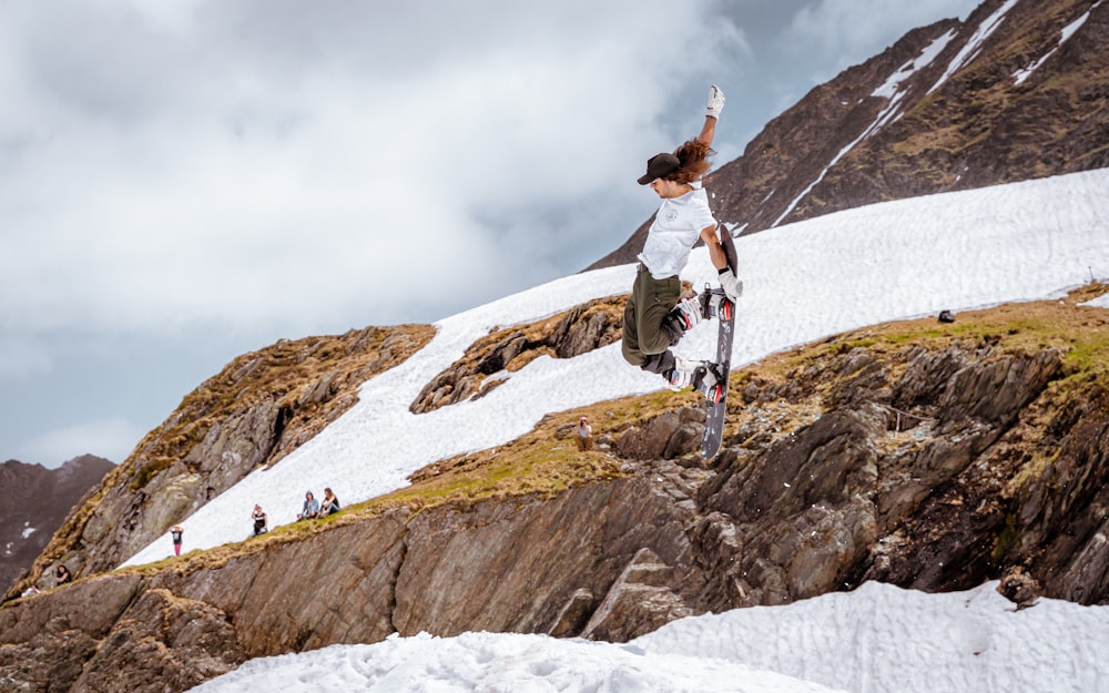 person wearing white shirt holding snowboard