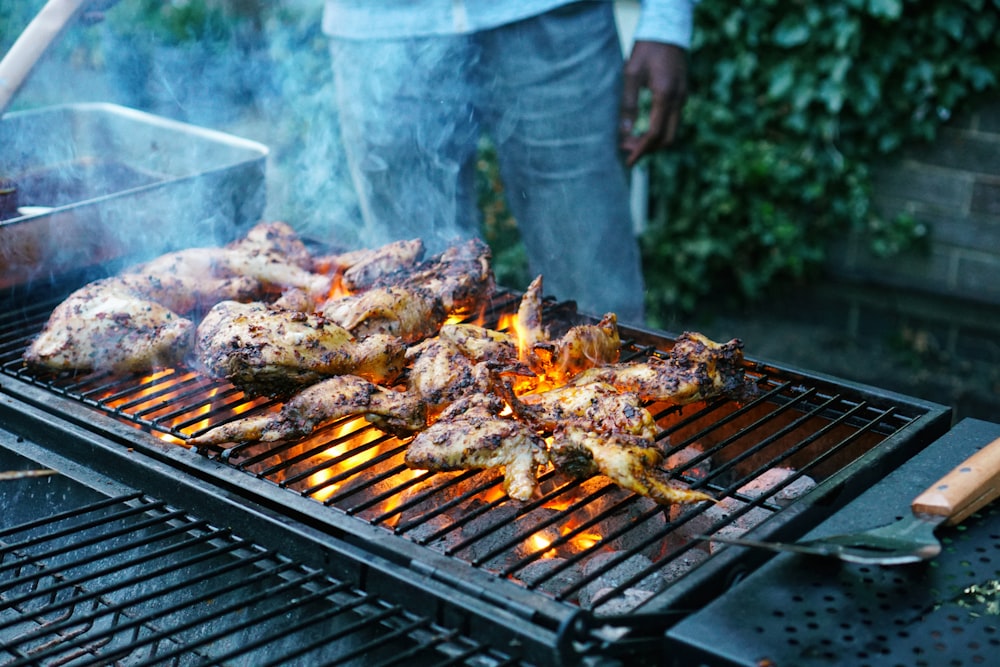 unknown person grilling chicken meat outdoors