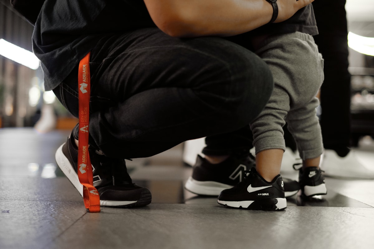 Person helping fit sneakers, checking size