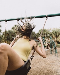 A playground with kids playing joyfully on swings and slides.
