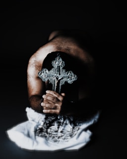 A close-up of hands holding a cross, symbolizing devotion and belief.