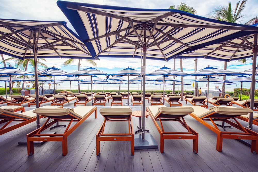 a bunch of chairs and umbrellas on a deck