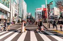 a group of people walking across a cross walk