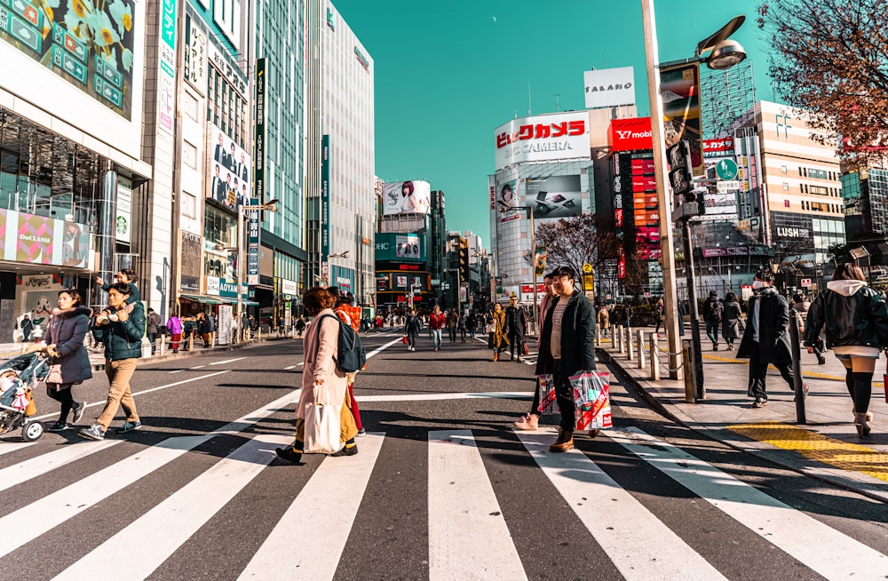 a group of people walking across a cross walk