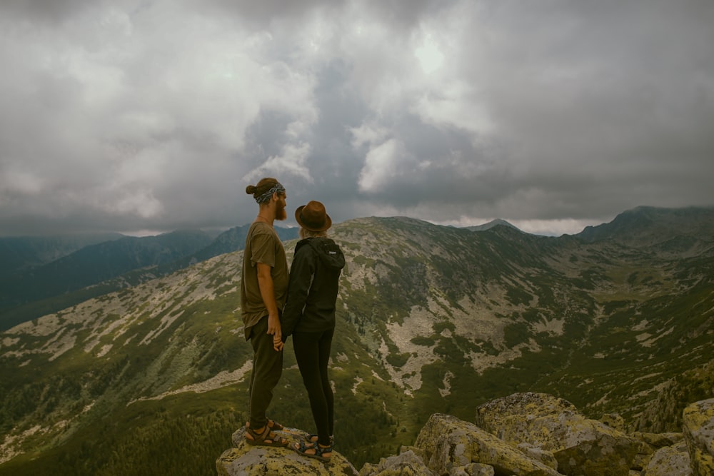 woman and man standin in the middle of mountain