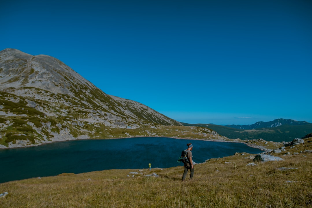 landscape photo of a man by a lake