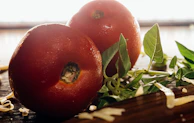Close-up of fresh tomatoes, basil leaves, and mozzarella arranged on a rustic table.