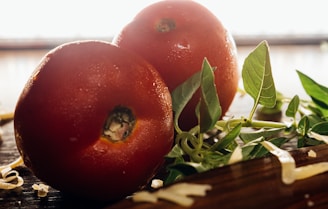 Close-up of fresh tomatoes, basil, and mozzarella cheese on a rustic wooden table.