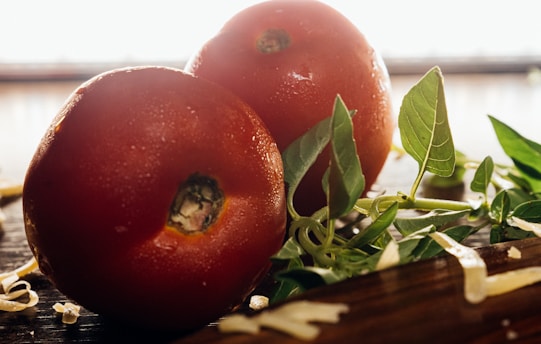 Close-up of fresh tomatoes, basil, and mozzarella cheese on a rustic wooden table.
