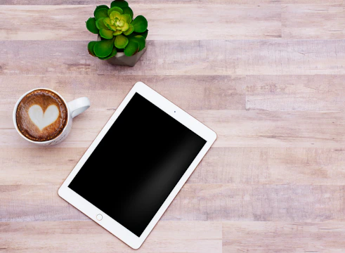A warm pastel-colored flat lay of the digital product on a tablet with a cup of tea nearby.