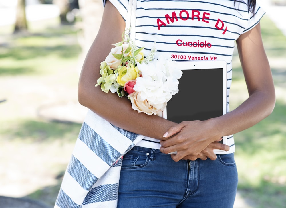 a woman in a striped shirt holding a bouquet of flowers
