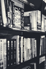 grayscale photography of books in bookcase