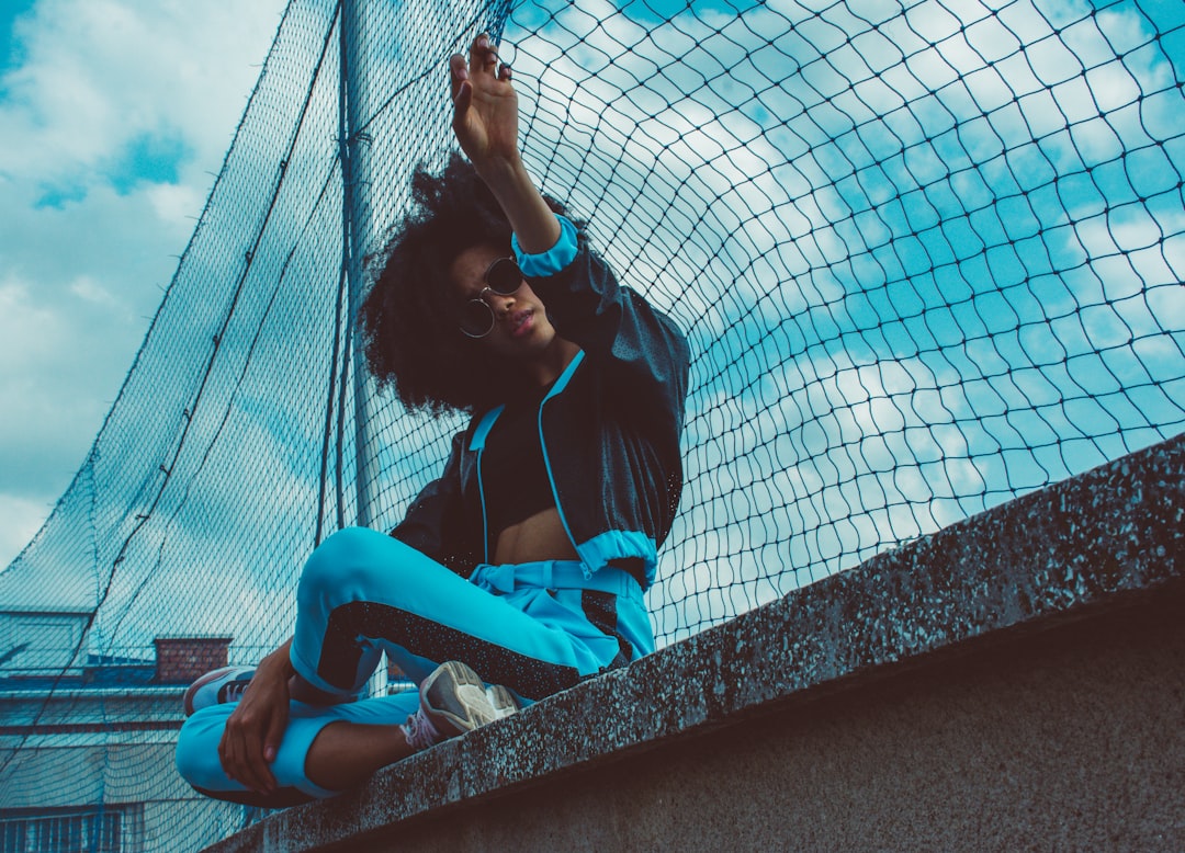 woman by a metal fence