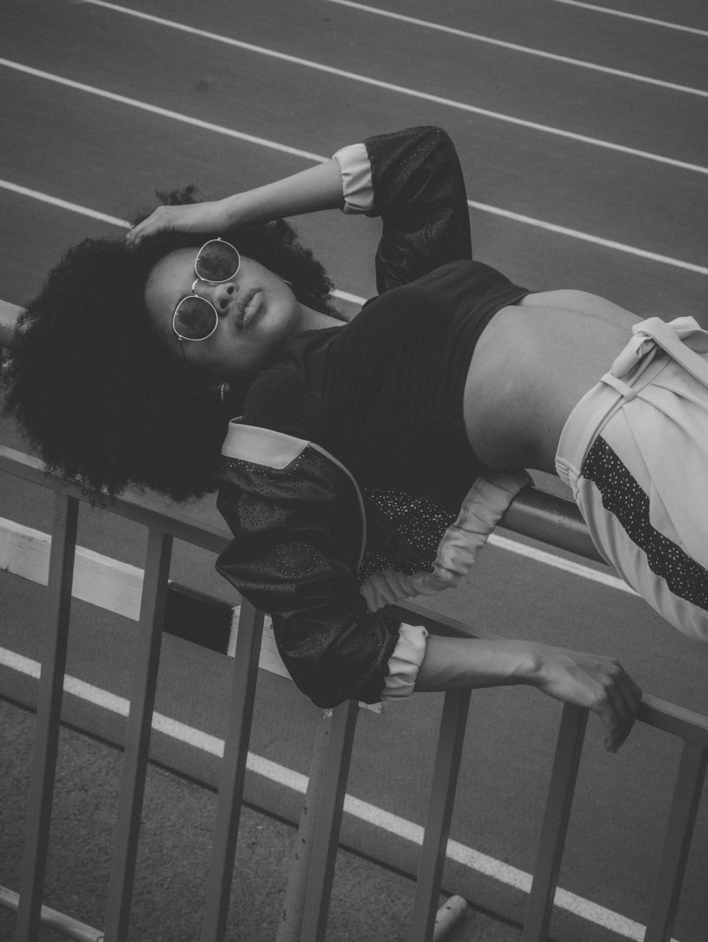 grayscale photo of woman wearing crop top and track pants