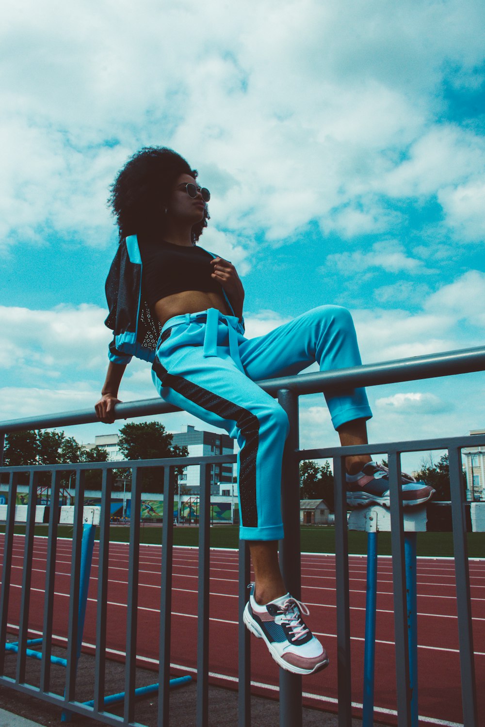 woman sitting on black metal rail during daytime