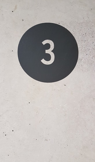 a black and white sign with the number three on it