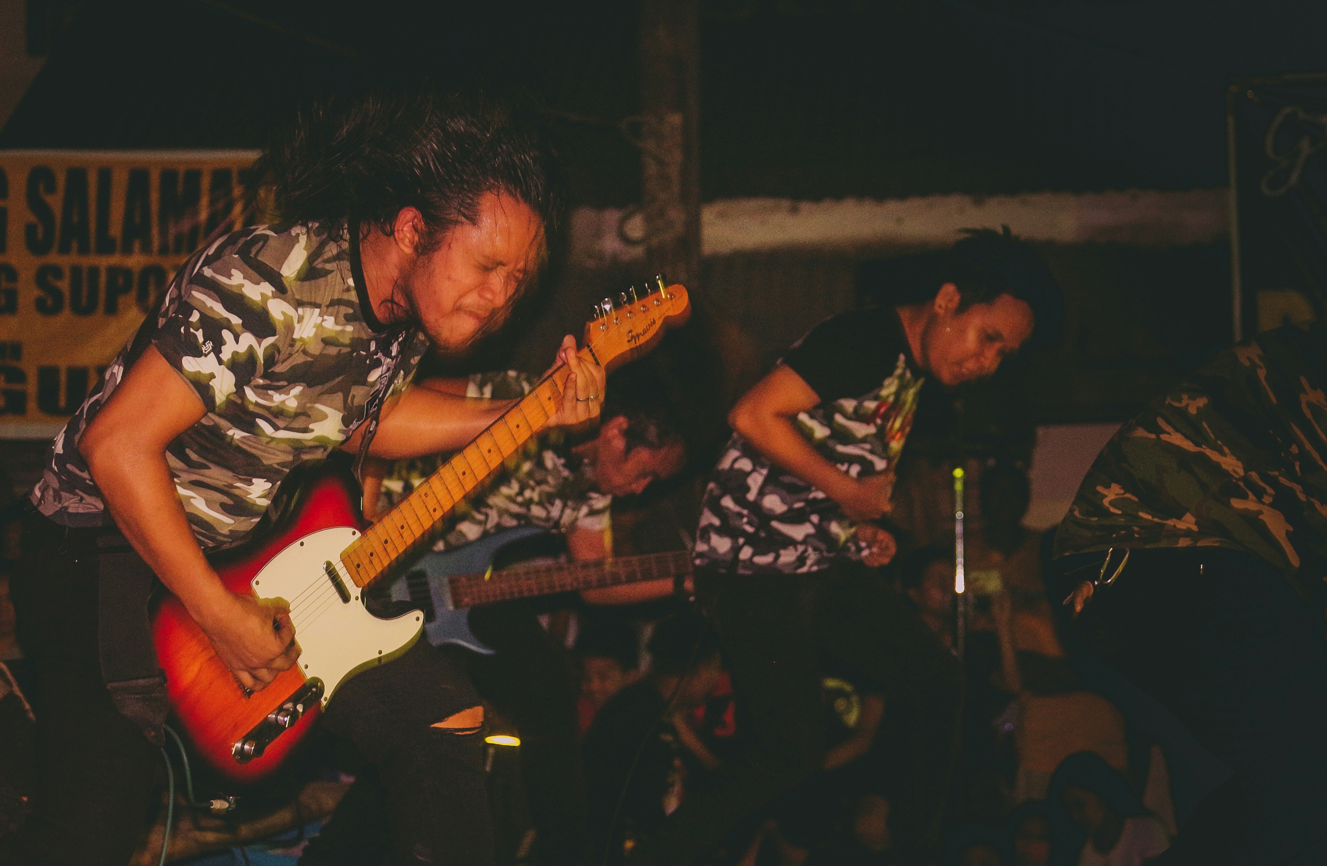 man playing electric guitar while closing his eyes