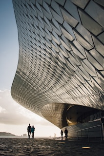 two person standing beside gray structure