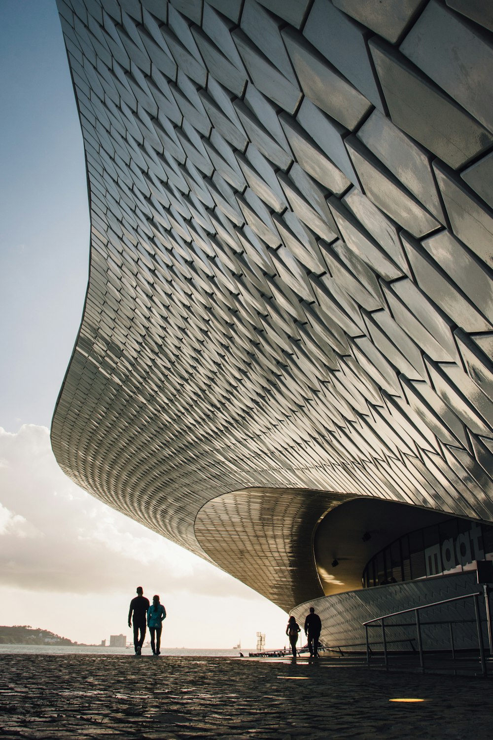 two person standing beside gray structure