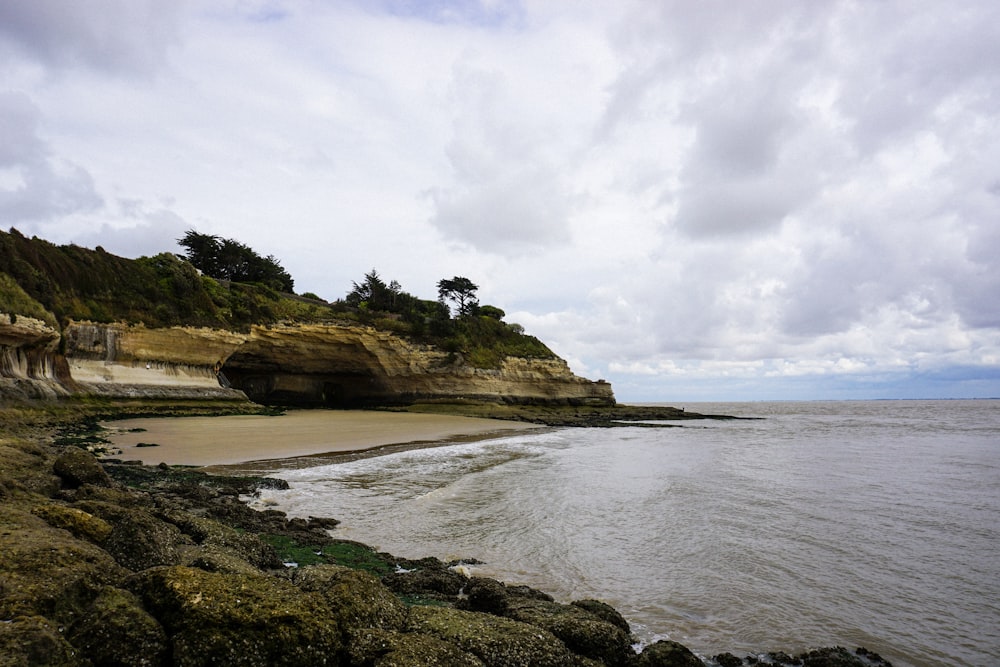 brown rock mountain beside seashore