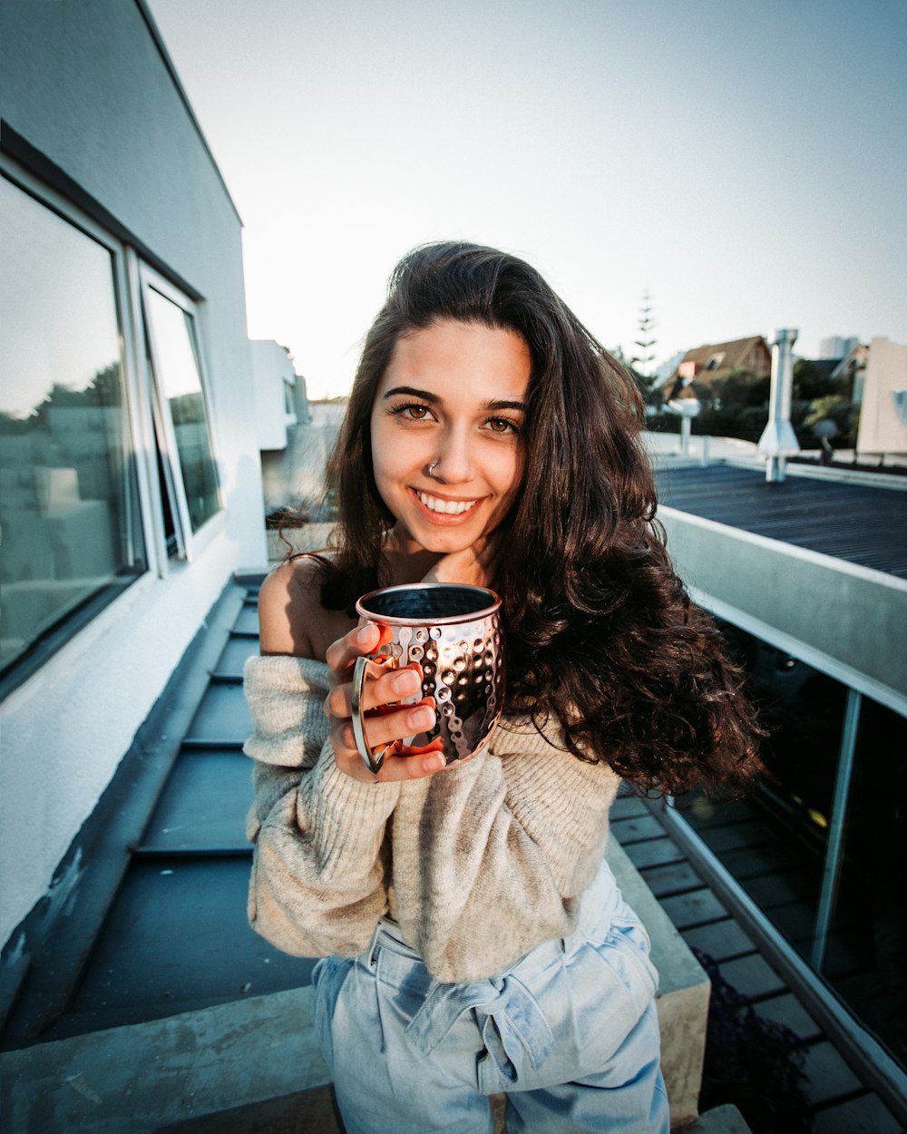 a woman is holding a coffee cup and smiling