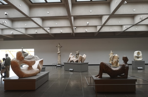 Visitors observing diverse artworks in a modern exhibition space.