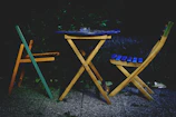 Outdoor scene showing a minimalist metal table with chairs arranged for an evening gathering.