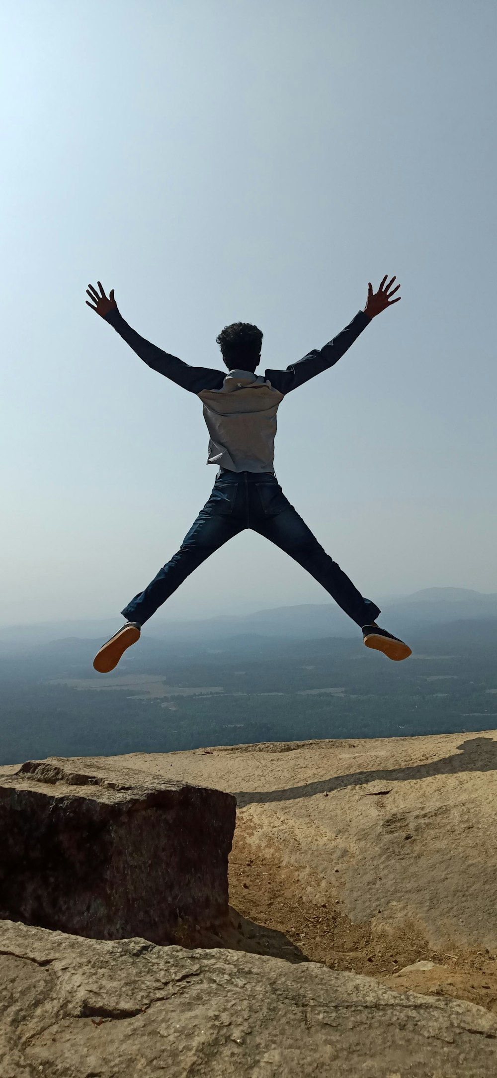 man jumping on rock formation