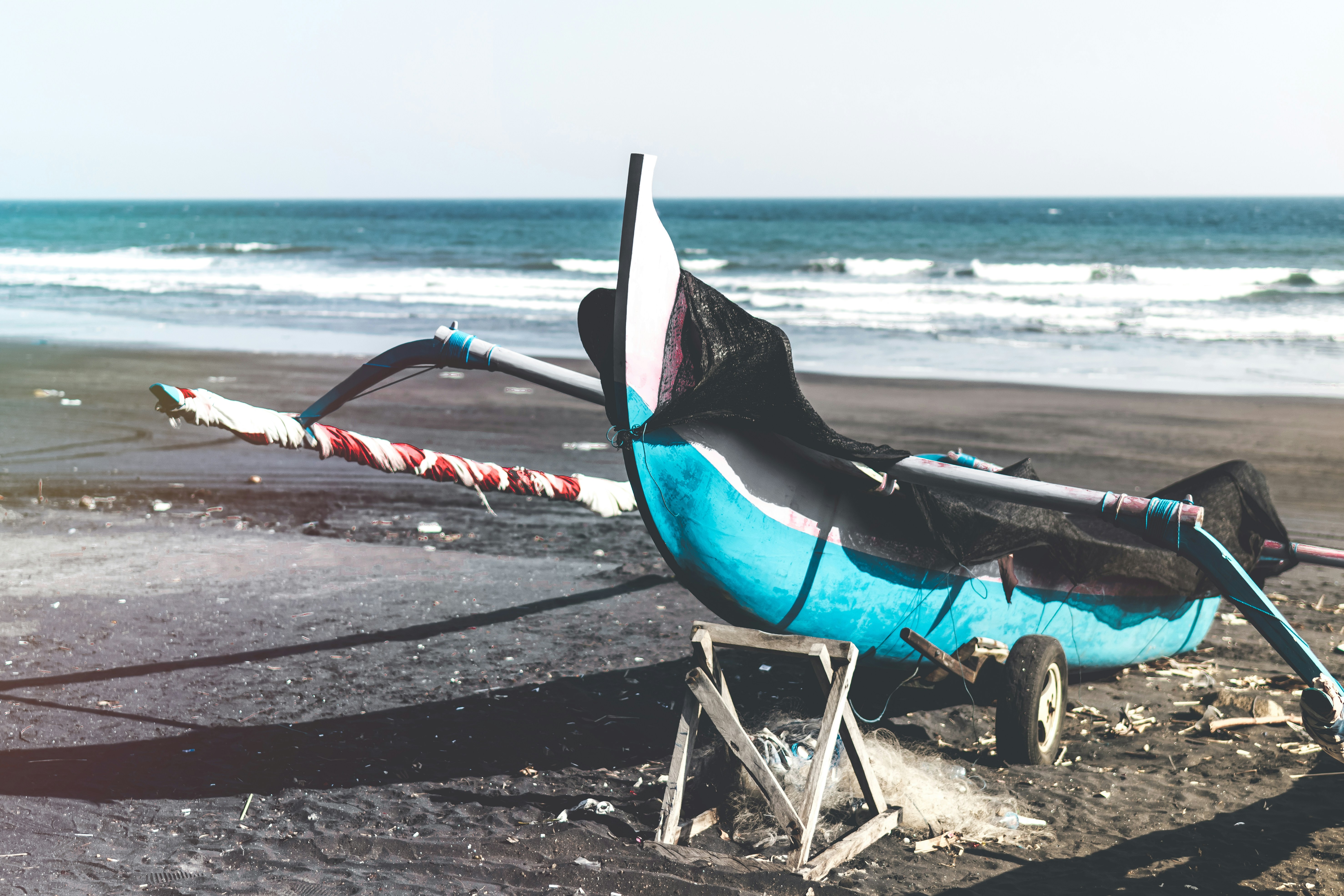 blue and white wooden fishing boat on a beach