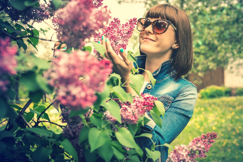 woman wearing sunglasses holding flower