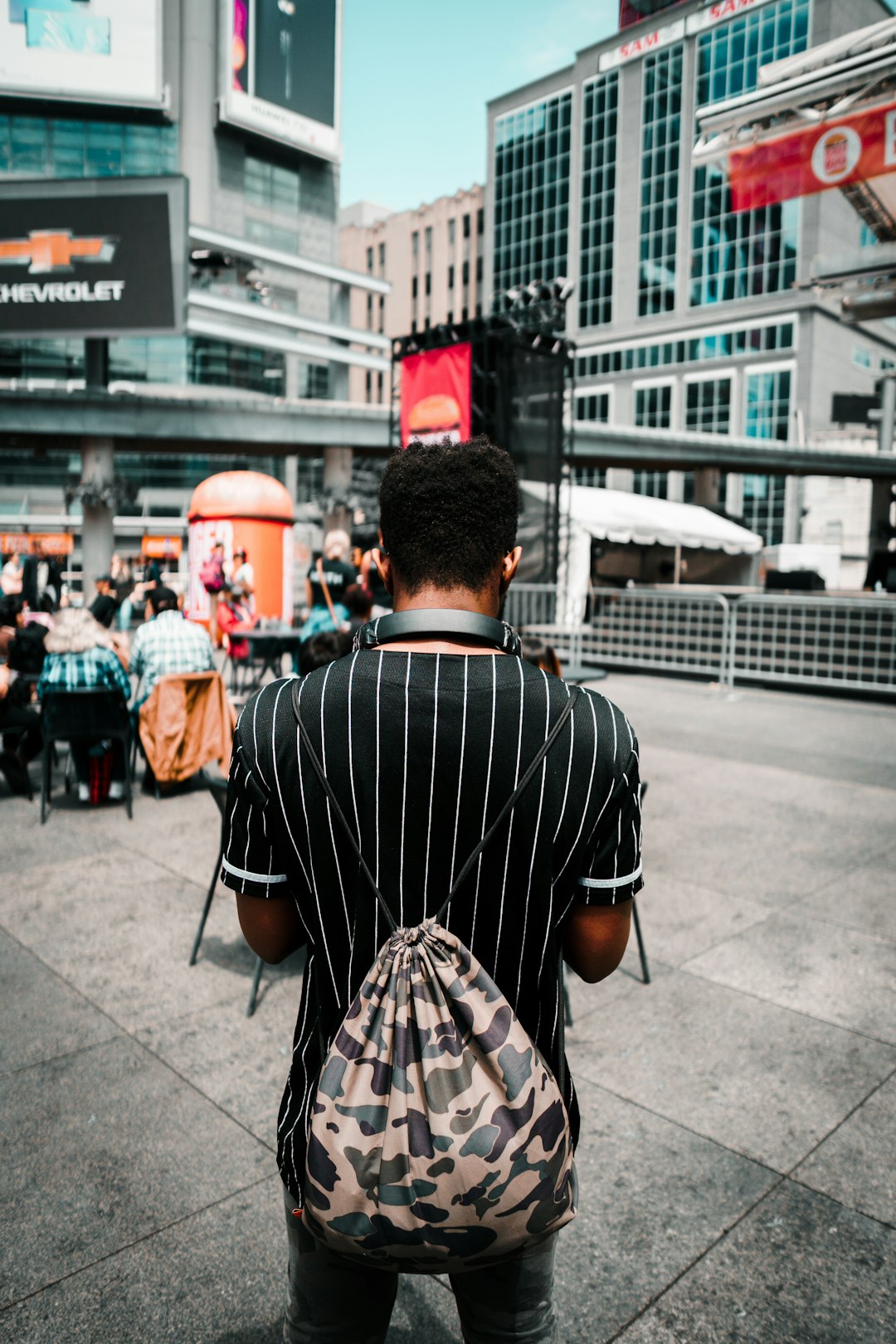 man carrying brown and gray camouflage backpack