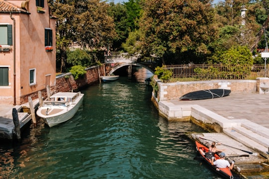 white boat on canal river during daytime in Giardini della Biennale Italy