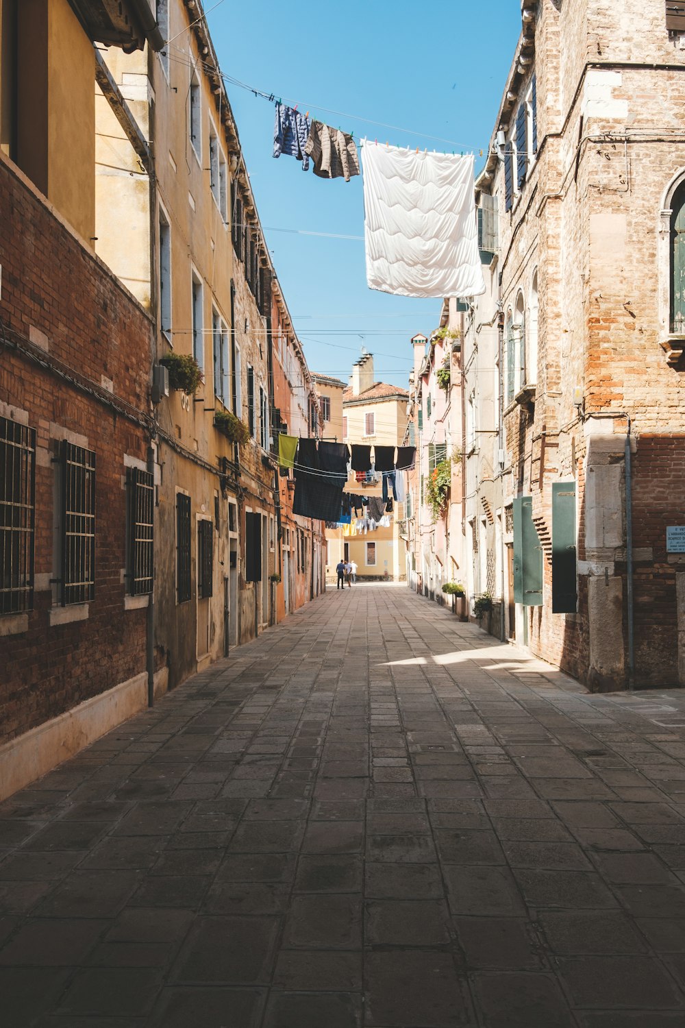 textiles hanging near houses during daytime