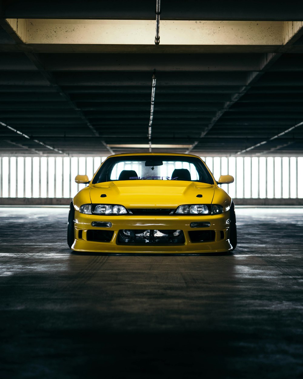 yellow sports car parking inside garage