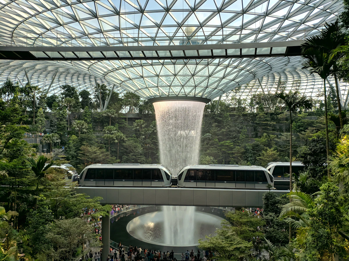 A modern train gliding through a futuristic indoor station with lush greenery