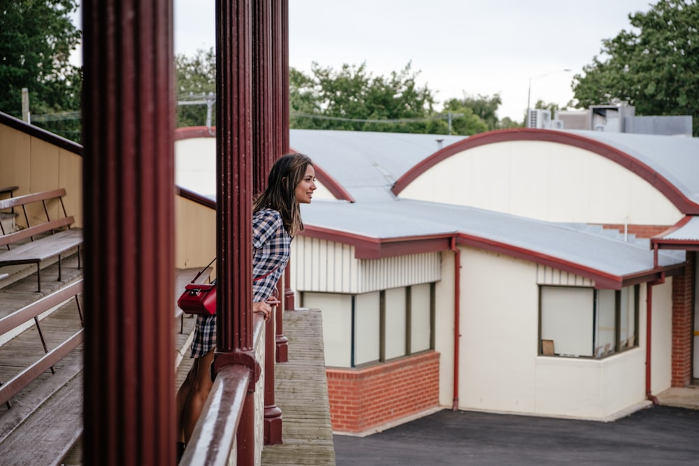 woman in blue and white plaid leaning on rails