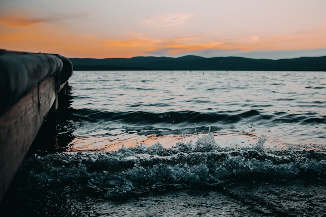 body of water across mountain during dusk