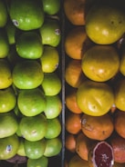 A close-up of ripe oranges and apples stacked together.
