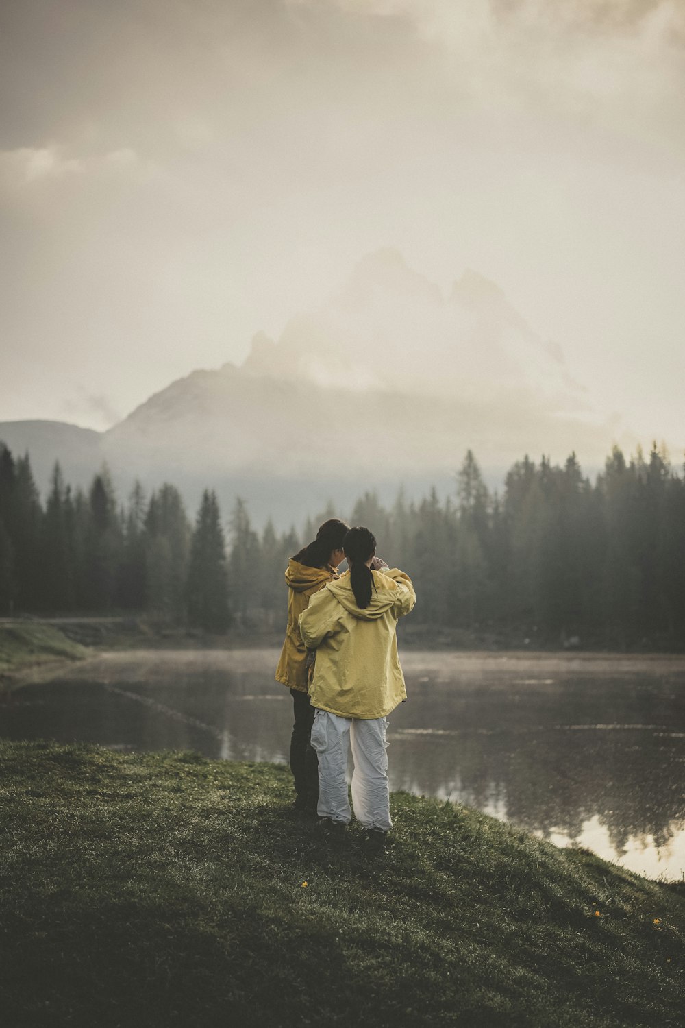 two person standing in front of body of water during daytime