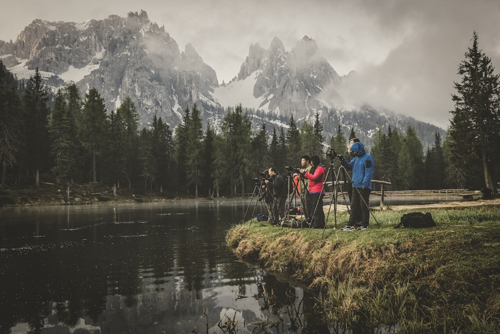 people standing beside body of water