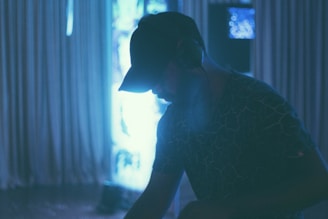 Lifestyle photo of DJ Kelblizz relaxing outdoors, headphones around his neck, city skyline in the background