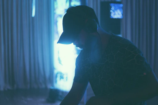 Close-up of a DJ spinning tracks with sleek silver headphones against a dark backdrop.