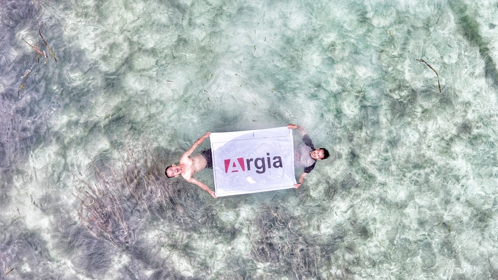 aerial view photo of two person holding Argia flag