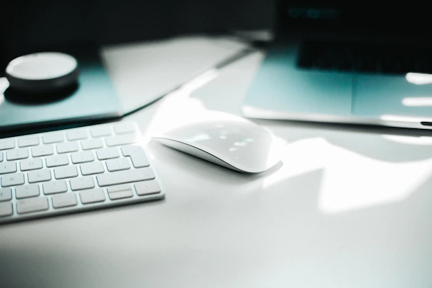 A sleek modern computer setup with a high-resolution monitor and wireless accessories bathed in soft natural light.