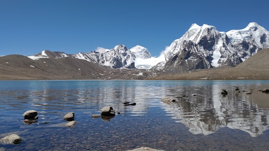 body of water near snow covered mountain in Gurudongmar Lake India