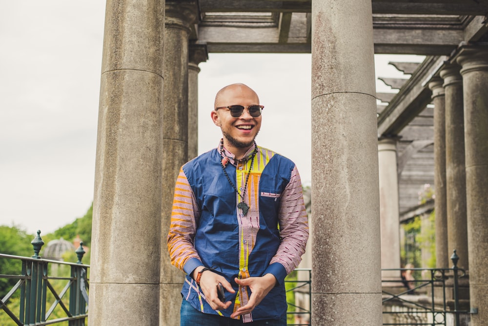 man standing between two gray cement columns