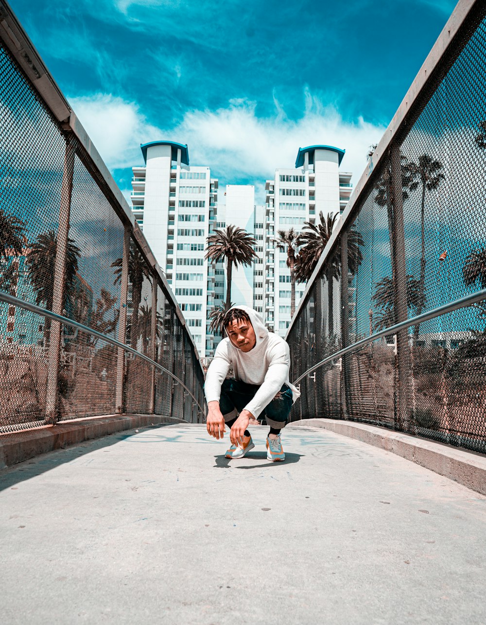 man squat sitting on bridge