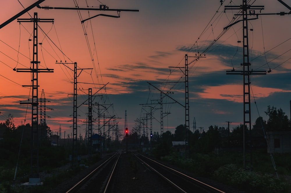 landscape photo of train tracks lined with electric towers