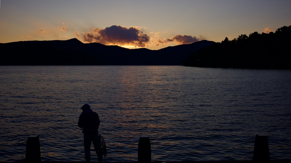 silhouette of man standing on dock