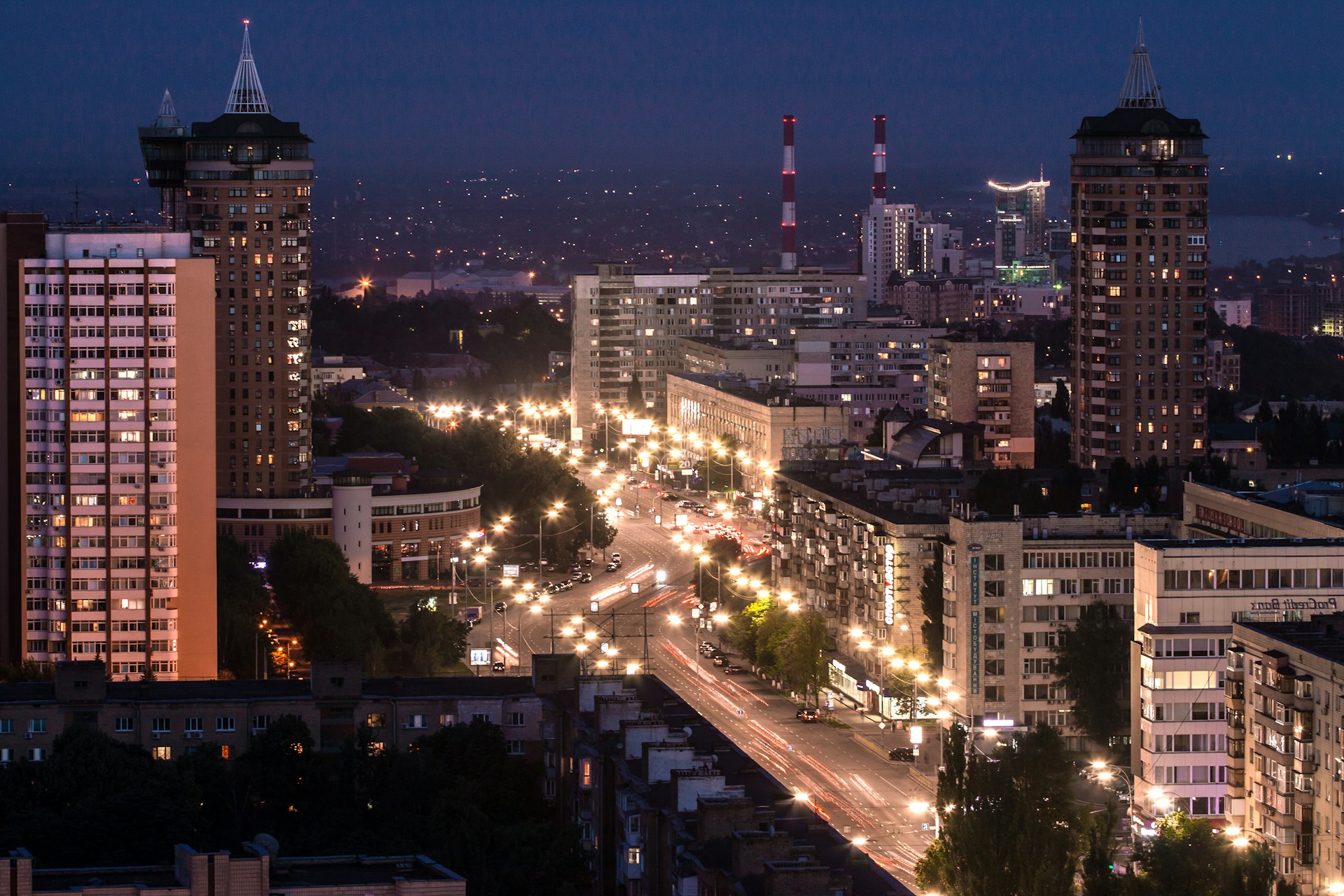 A cinematic shot of a bustling cityscape at dusk, highlighting dynamic lighting and movement.
